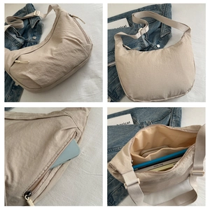 Detail view of large capacity beige crescent shoulder bag with adjustable strap and zip pocket