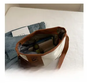 Detail of spacious canvas tote interior holding a tablet, book, and umbrella