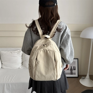 Lightweight beige nylon backpack with multiple zipper pockets for students and travel
