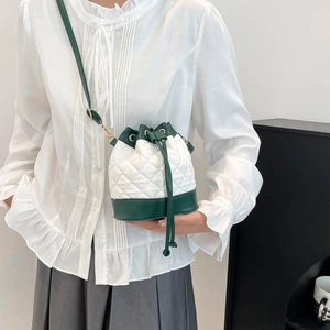 Quilted drawstring bucket bag in green and white leather with gold hardware