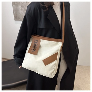 Détail du sac fourre-tout en toile beige avec finitions en cuir brun et bandoulière