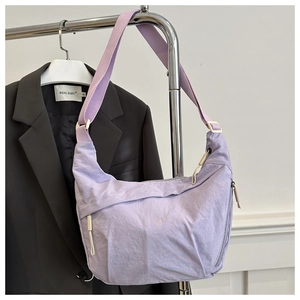 Detail view of the light purple nylon crescent bag with adjustable wide strap and zipper
