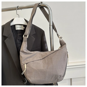Detailed view of dark grey nylon crescent bag with adjustable strap and metal hardware