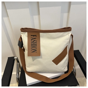 Détail du sac fourre-tout en toile blanc cassé avec bordure marron et texte mode