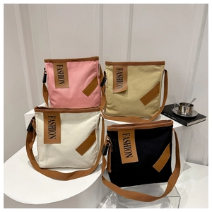 Detail view of canvas tote bags in pink, beige, white, and black with fashion patches