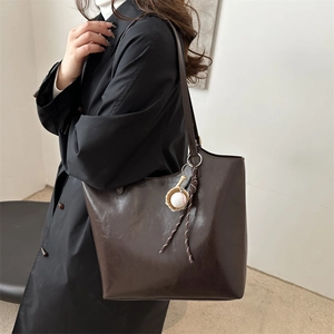 Minimalist vintage dark brown soft leather tote bag with a baseball charm for daily commute