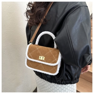 Detailed view of brown suede mini bag with shearling trim and gold buckle worn by model
