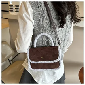 Brown quilted shoulder bag with white faux fur trim and gold twist lock on model