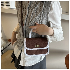 Detail of faux shearling trim and quilted suede texture on chic brown crossbody bag