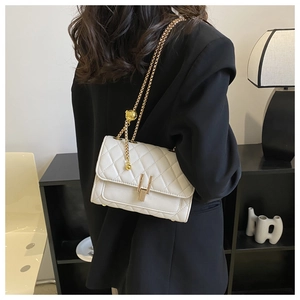 Vista posteriore di una modella con borsa trapuntata bianca e tracolla dorata