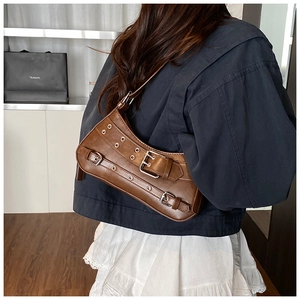 Gros plan du sac à bandoulière marron rétro avec boucles et style punk chic