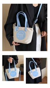 Détails du sac cabas en nylon contrasté avec bordure bleue et bandoulière amovible réglable