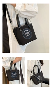 Détail du sac en nylon noir avec coutures blanches contrastées et logo rond