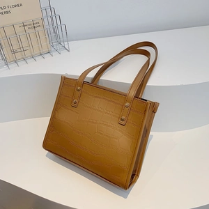 Brown crocodile embossed faux leather tote bag with wide handles and metal rivets