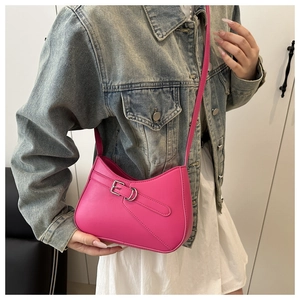 Detalle del bolso de cuero fucsia tipo media luna con hebilla plateada y correa ajustable