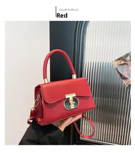 Detail of red glossy leather handbag with rectangular flap and metal buckle