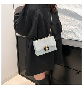 Détail du sac à main bleu clair perlé avec fermoir en T doré et bandoulière chaîne