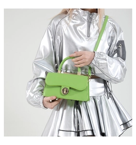Lime green leather mini crossbody bag with golden rotary lock worn by model