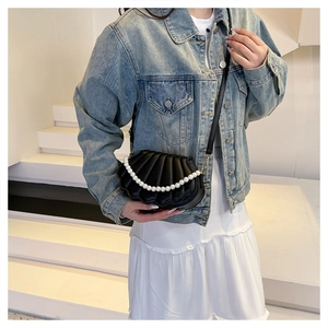 Black shell-shaped leather crossbody bag with elegant pearl handle and quilted texture