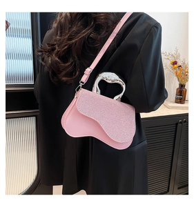 Detail of pink crossbody bag with glitter flap and irregular silver metal handle