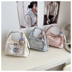 Detailed view of clear PVC window on ita-bags with badges and plush charms for decoration