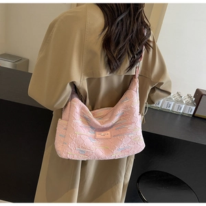 Pink textured canvas tote bag with colorful embroidery details on a female model