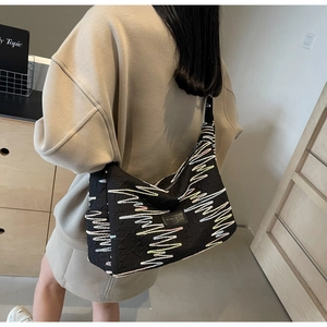 Detail of black canvas tote bag featuring textured jacquard pattern and colorful wavy lines