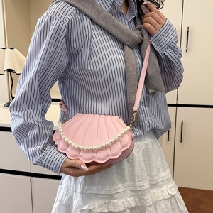 Elegant pink shell-shaped crossbody bag with decorative pearl chain and shoulder strap