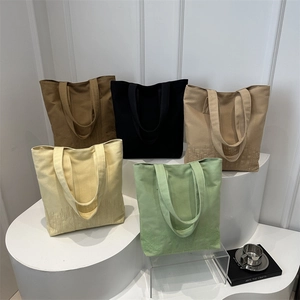 Group of minimalist canvas tote bags in five colors on geometric display shelves