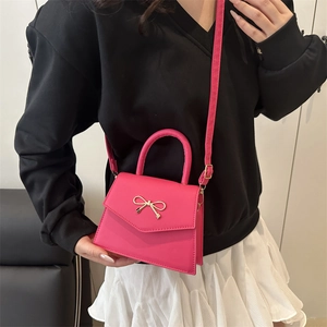 Rose red bow shoulder bag with gold hardware and trapezoid flap in luxury PU leather
