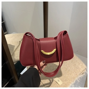Detail of wine red leather baguette bag featuring a distinct crescent gold metal buckle