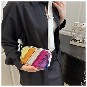 Detail of colorful metallic striped crossbody bag with a wide white nylon strap