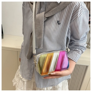 Detail view of colorful metallic rainbow striped crossbody bag shown on a model