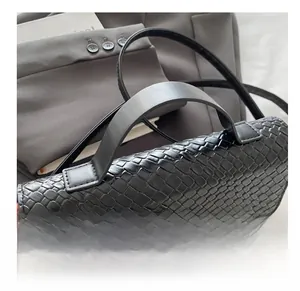 Detailed view of black crocodile pattern leather texture with golden rotating lock buckle