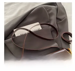 Detailed macro view of the brown patent leather texture and gold hardware on the handbag
