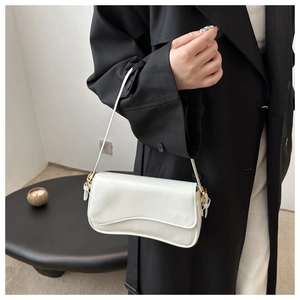 Détail du sac baguette en cuir verni blanc avec rabat ondulé et boucles dorées