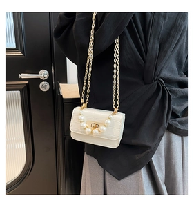 Détail du mini sac blanc motif croco avec poignée en perles et bandoulière chaîne dorée