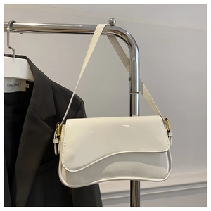 Détail d'un sac bandoulière en cuir verni blanc avec boucle dorée et rabat incurvé