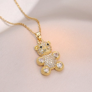 Gros plan d'un collier pendentif ours doré serti de zircons blancs et noirs scintillants