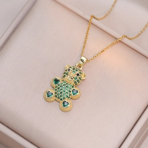 Collier pendentif ourson doré avec zircons verts en forme de cœur sur boîte à bijoux