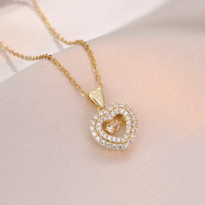 Collier cœur doré élégant avec pierre dansante et cristaux sur tissu en soie