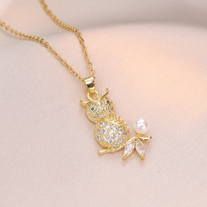 Elegant gold owl pendant necklace with full cubic zirconia and pearl on silk