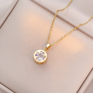 Elegant gold clover necklace with four heart-shaped zircons on a soft velvet cushion