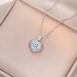 Vue macro d'un pendentif coeur en argent serti de zircons et d'un œil maléfique