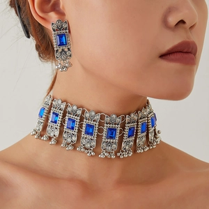 Vintage jewelry set with blue gemstones and metallic tassels on a fashion model