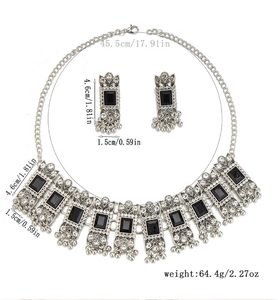 Detail view of vintage silver jewelry set with black gemstones and geometric necklace design