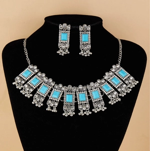 Detail of vintage bohemian jewelry set with turquoise gems and metal tassels on display