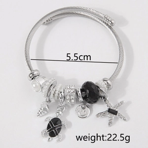 Detail showing starfish and turtle charms on twisted silver wire bracelet with 5.5cm diameter