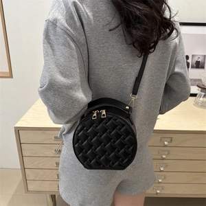 Quilted round black crossbody bag for women with gold hardware and top handle