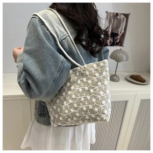 Détail de broderie dentelle florale et poignée en corde de coton sur cabas tissé beige